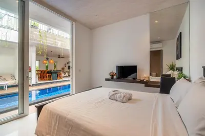 a bedroom with a large bed and a swimming pool at La Terra Villas Canggu Kuta Bali in Canggu