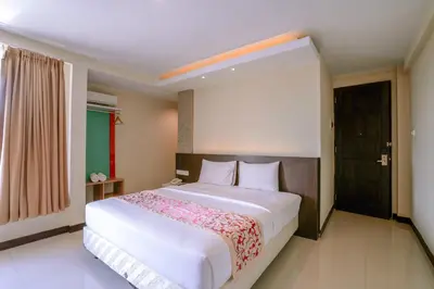 a bedroom with a large white bed in a room at Balitone Guest House in Denpasar