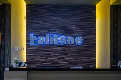 a wall with a blue sign on a brick wall at Balitone Guest House in Denpasar