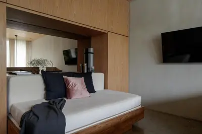 a bedroom with a white bed with blue and pink pillows at OXO Townhouses Umalas - Close to Seminyak & Canggu in Seminyak