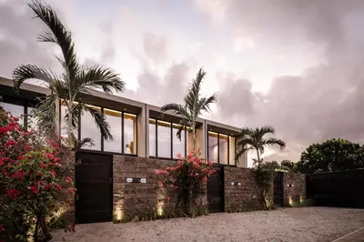 a house with glass windows and palm trees at OXO Townhouses Umalas - Close to Seminyak & Canggu in Seminyak
