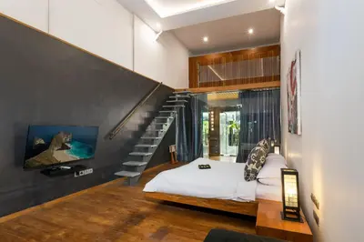 a bedroom with a bed and a staircase at Saga Villas ULTRA in Seminyak