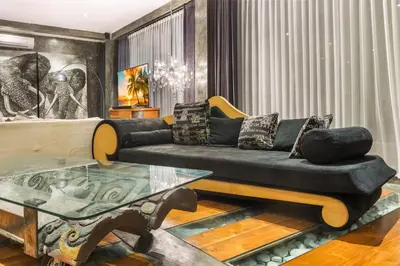 a living room with a black couch and a glass table at Saga Villas ULTRA in Seminyak
