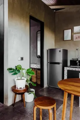 a kitchen with a refrigerator and a table and chairs at T Lofts in Seminyak