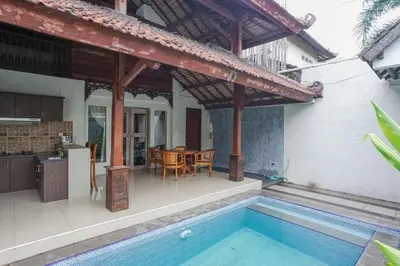 a house with a pool and a patio with a table at Balitung Villa Seminyak in Seminyak