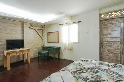 a bedroom with a bed and a television and a desk at Balitung Villa Seminyak in Seminyak