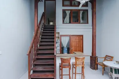 a staircase in a room with chairs and a table at Balitung Villa Seminyak in Seminyak