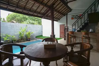 a dining room with a table and chairs and a pool at Balitung Villa Seminyak in Seminyak