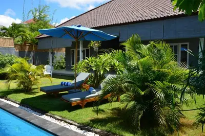 a house with a pool and a blue umbrella at Villa Eden Seminyak in Seminyak