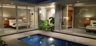 a room with a swimming pool and a bedroom at Villa Teejay - architect-designed luxury in perfect Petitenget location in Seminyak