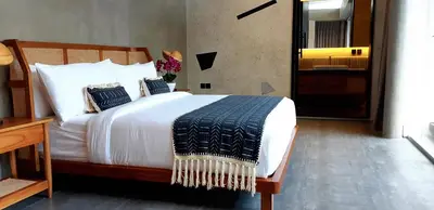 a bedroom with a large bed with white sheets and pillows at Villa Teejay - architect-designed luxury in perfect Petitenget location in Seminyak