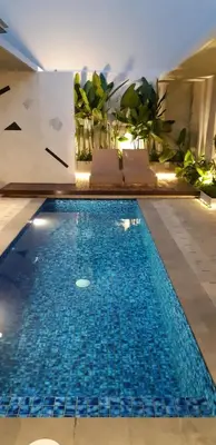 a swimming pool with blue water in a building at Villa Teejay - architect-designed luxury in perfect Petitenget location in Seminyak
