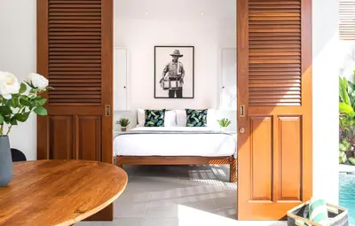 a bedroom with a bed and a table at Villa Revo in Seminyak