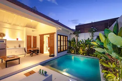 a backyard with a swimming pool and a house at Villa Revo in Seminyak