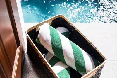 a basket with green and white towels in it at Villa Revo in Seminyak
