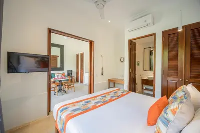 a bedroom with a bed and a table in a room at Villa Joli in Seminyak