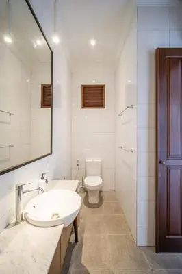 a bathroom with a sink and a toilet and a mirror at Villa Jolaine in Seminyak