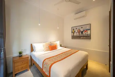 a bedroom with a bed and a painting on the wall at Villa Jolaine in Seminyak