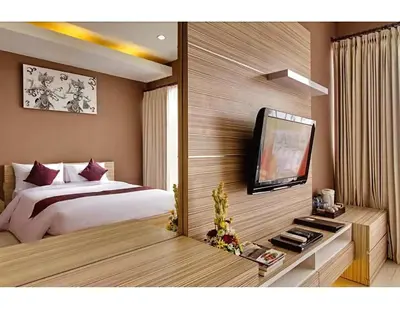 a bedroom with a bed and a flat screen tv at ABISHA Resort Jimbaran in Jimbaran