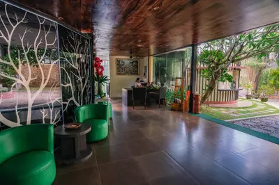 a lobby with green chairs and a bedroom at ABISHA Resort Jimbaran in Jimbaran
