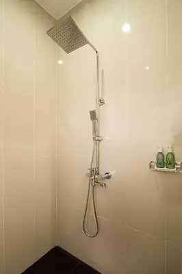 a shower with a shower head in a bathroom at ABISHA Resort Jimbaran in Jimbaran