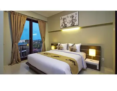 a bedroom with a large bed and a large window at ABISHA Resort Jimbaran in Jimbaran
