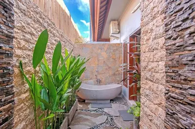 a bathroom with a bath tub in a courtyard at Villa Ellen in Seminyak