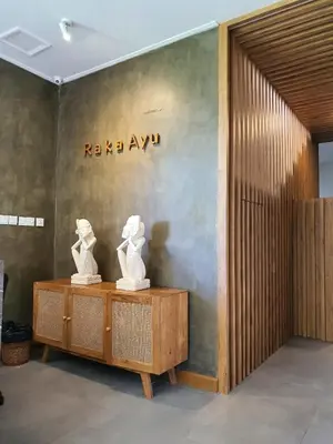 two white statues on a table in front of a wall at RakaAyu Kuta in Kuta