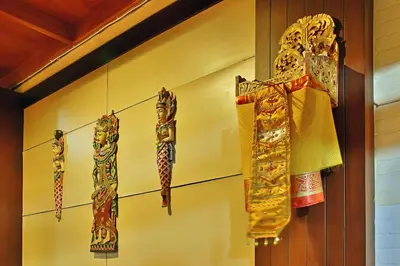 a group of scarves hanging on a wall at Puri Naga Beachfront Cottages in Legian