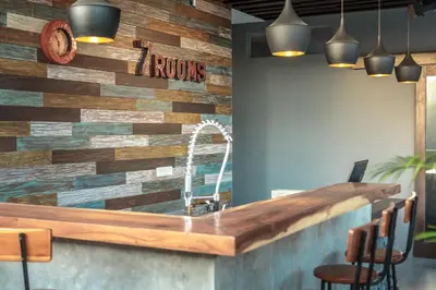 a bar in a restaurant with a stone wall at 7Rooms Villa Seminyak in Seminyak