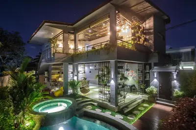a house with a swimming pool at night at 7Rooms Villa Seminyak in Seminyak