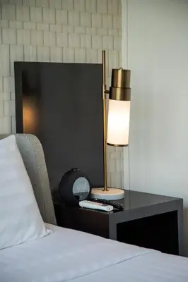 a bed with a desk with a lamp on it at The Claremont Luxury Villas in Seminyak