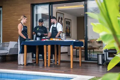 a group of three people standing around a table at The Claremont Luxury Villas in Seminyak
