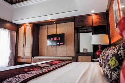 a bedroom with a bed and a sign on the wall at Sampatti Villas in Seminyak
