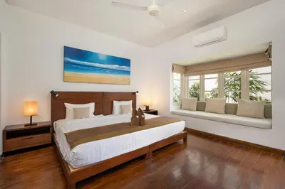 a bedroom with a large bed and two windows at 2BR Private Villa Seminyak, Villa Kiran One in Seminyak