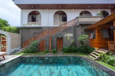 a house with a swimming pool in front of a house at Moson Villa Legian in Legian