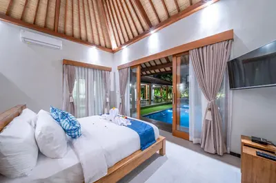 a bedroom with a bed and a tv at Villa Litera Canggu Bali in Canggu