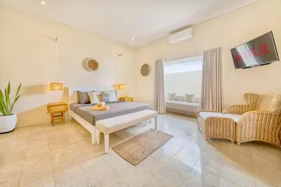 a bedroom with a bed and a tv and a chair at Villa Milano - Private 6 BDR Villa in Seminyak, prime Location, Pool & Garden in Canggu