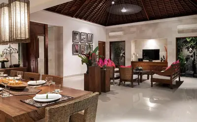 a dining room and living room with a table and chairs at Villa Songket in Kerobokan