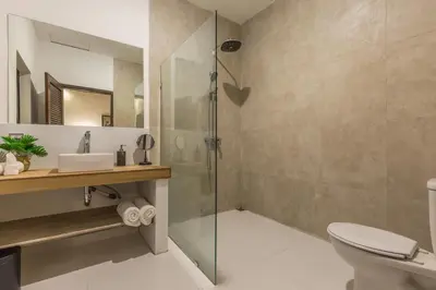 a bathroom with a shower and a toilet and a sink at Villa Bunga 1 in Seminyak