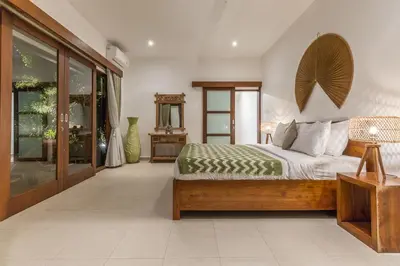 a bedroom with a bed and a large window at Bunga 2 in Seminyak