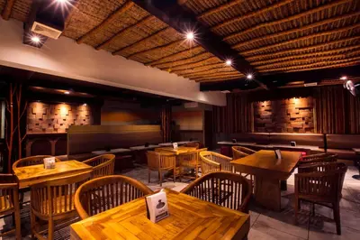 a dining room with wooden tables and chairs at Bali Bungalo Hotel in Kuta