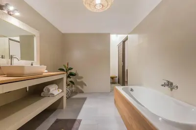a white bathroom with a tub and a sink at Pulesari 3 bedrooms in Seminyak