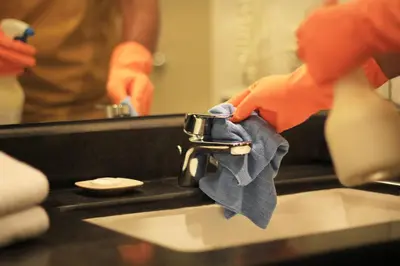 a person is washing a sink with a towel at The Haere Seminyak - By Astadala in Seminyak