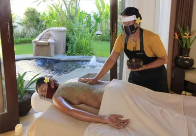 a man laying on a bed getting a massage at The Haere Seminyak - By Astadala in Seminyak