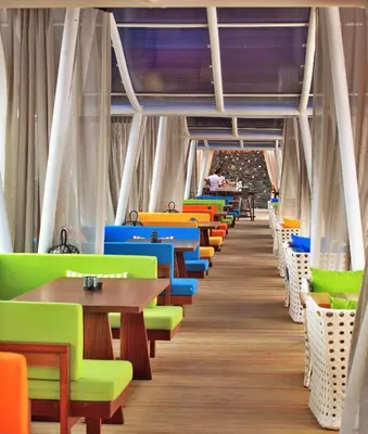 a row of tables and chairs in a restaurant at TS SUITES Seminyak Bali in Legian