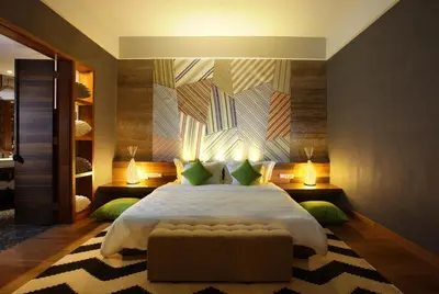 a bedroom with a large bed and a couch at TS SUITES Seminyak Bali in Legian