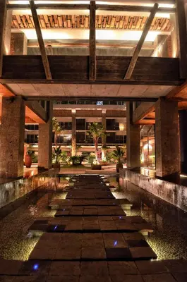 a building with a pool of water in front of it at TS SUITES Seminyak Bali in Legian