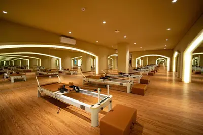 a row of beds in a large room with wooden floors at TS SUITES Seminyak Bali in Legian