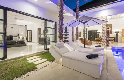 a living room with a white couch and an umbrella at Villa Lora in Seminyak